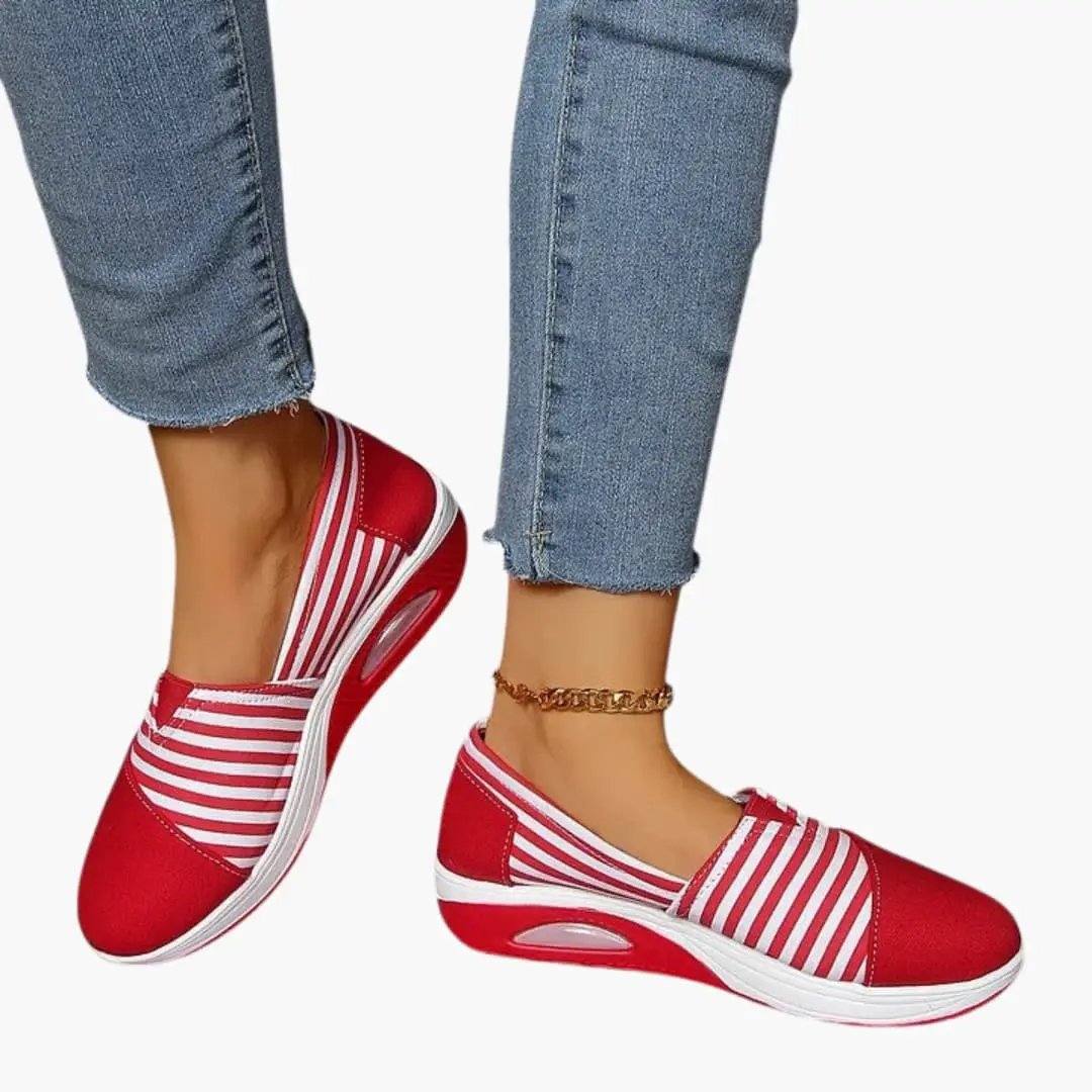Women's orthopedic slip-on sneakers in red and white striped uppers with a textured sole.