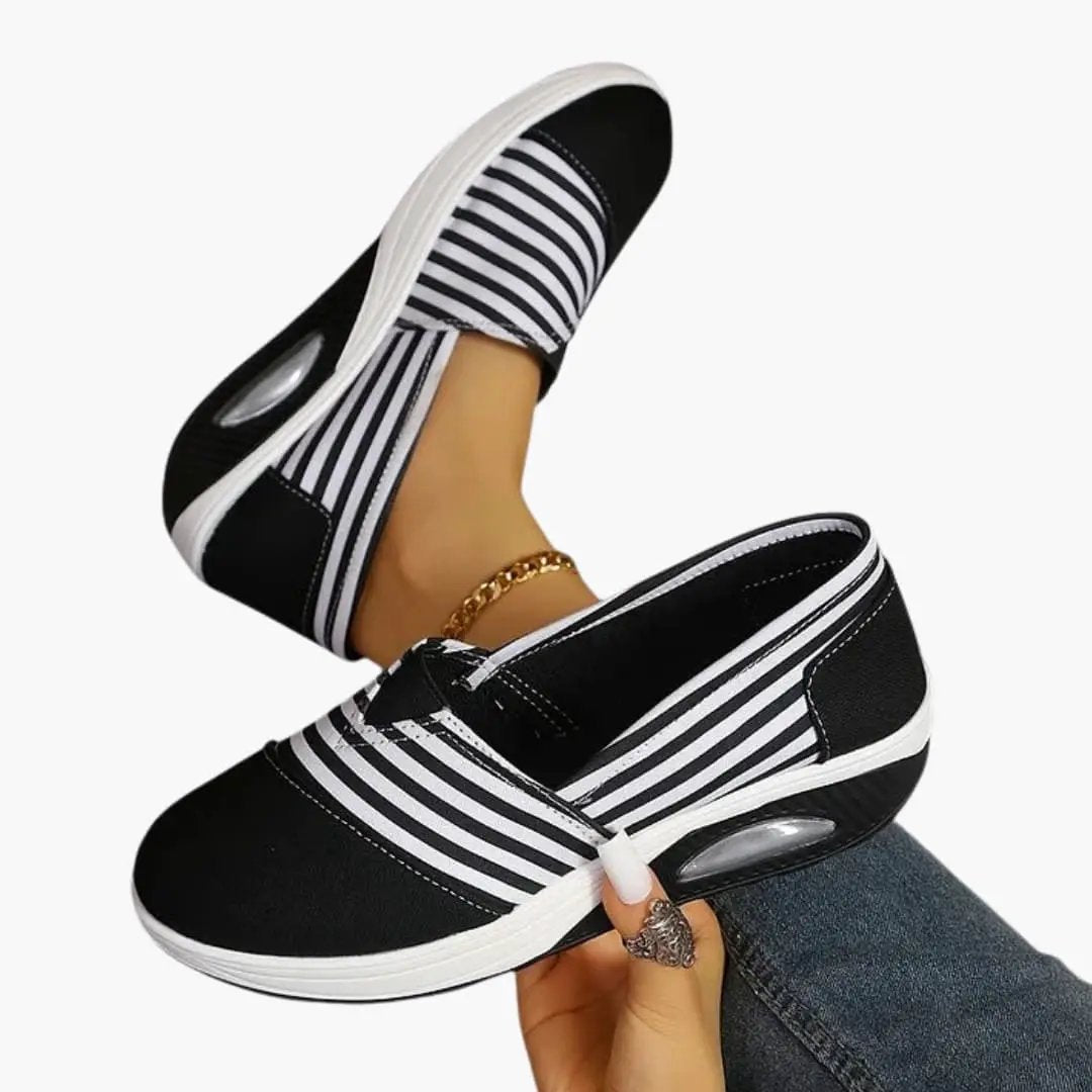 Pair of women's orthopedic slip-on sneakers in black and white stripes with a textured sole