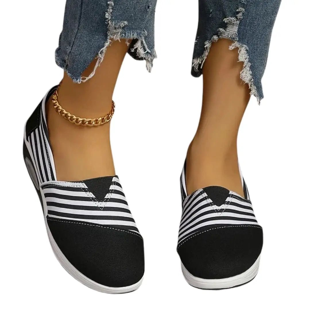 Pair of women's orthopedic slip-on sneakers with black-and-white stripes and white sole