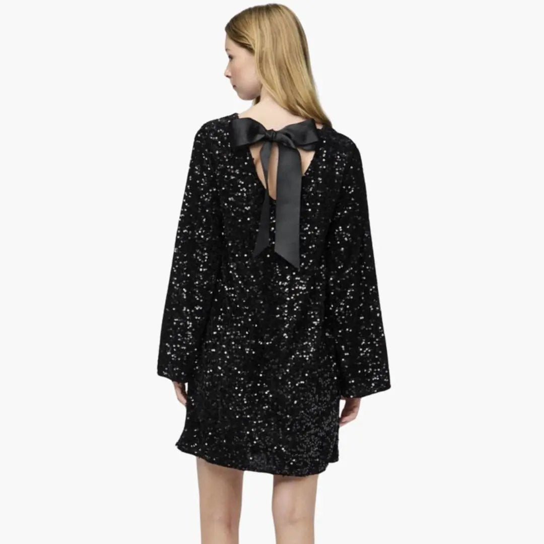 Women's black sequin mini dress with back bow detail, rear view.