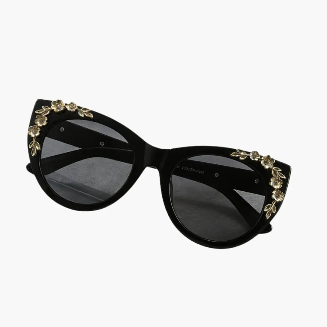 Women's sunglasses by Wilfred Smith with black cat-eye frame and gold floral accents, UV400 polycarbonate lenses