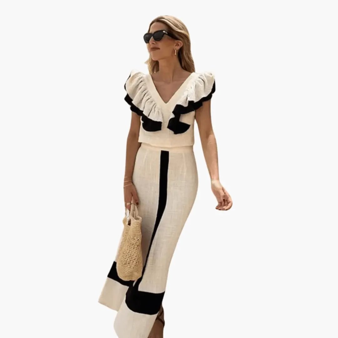 Women's two-piece set by Wilfred Smith: cream long-sleeve top with black ruffle trim and matching straight-leg pants.