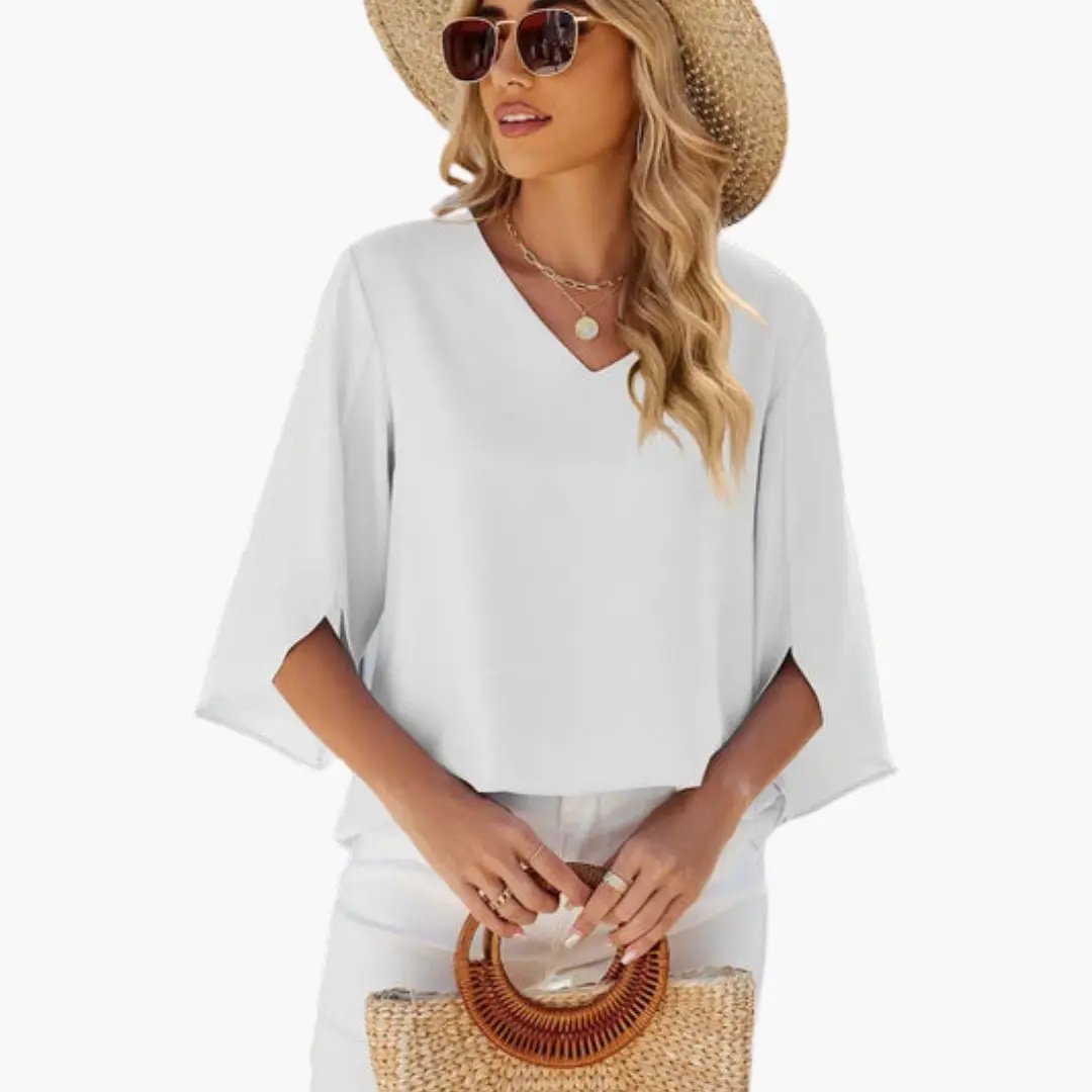 Women’s V-Neck Long Sleeve Blouse in white with flowing batwing sleeves, styled with a straw hat and woven handbag.