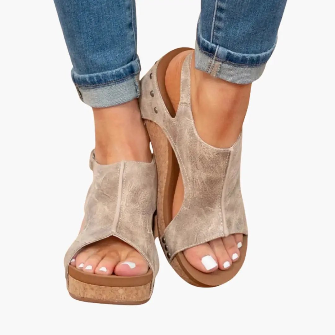 Pair of women's wedge sandals with taupe suede uppers, cork wedges, and elastic straps.
